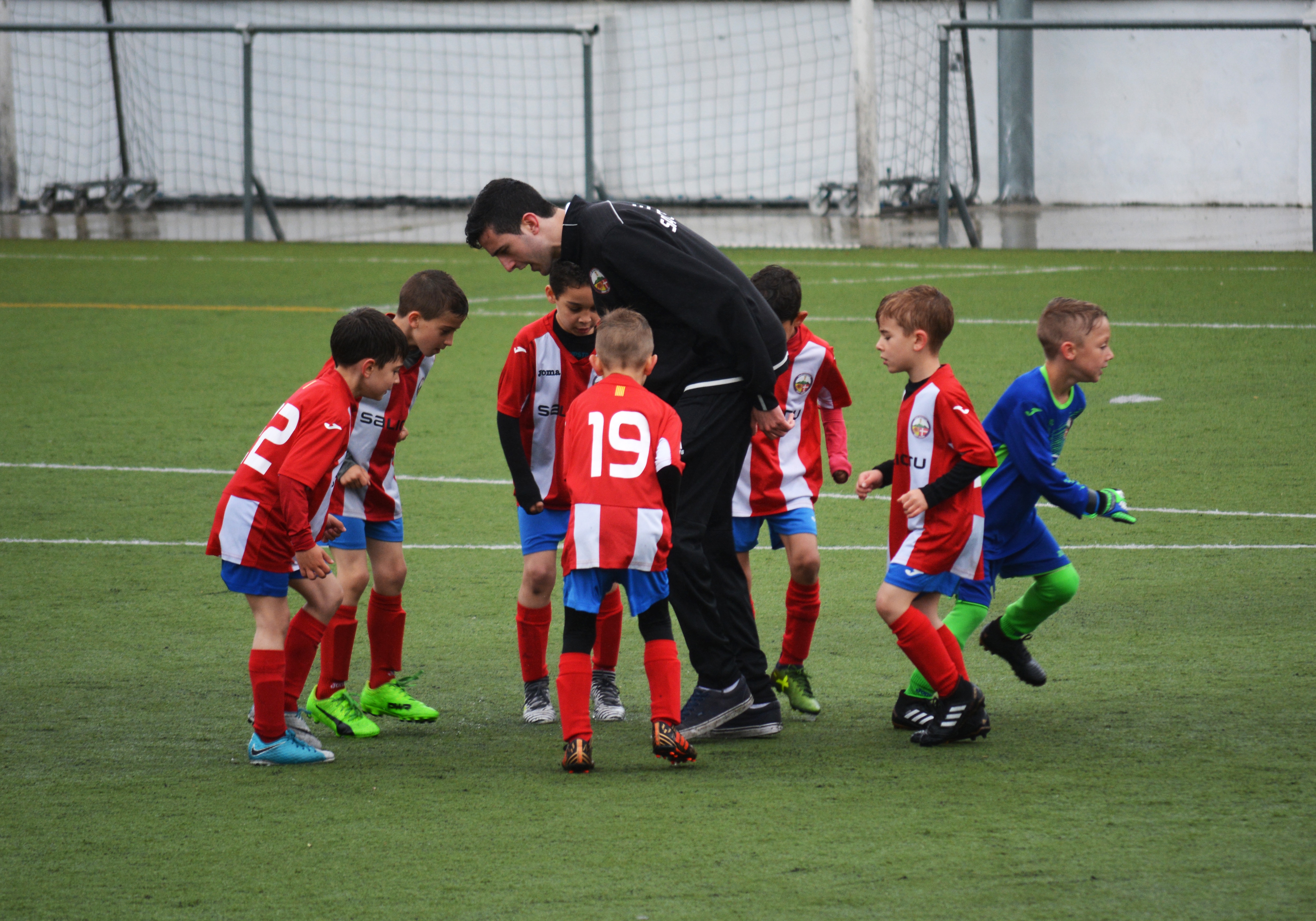 Seven boys in a football practice with coach