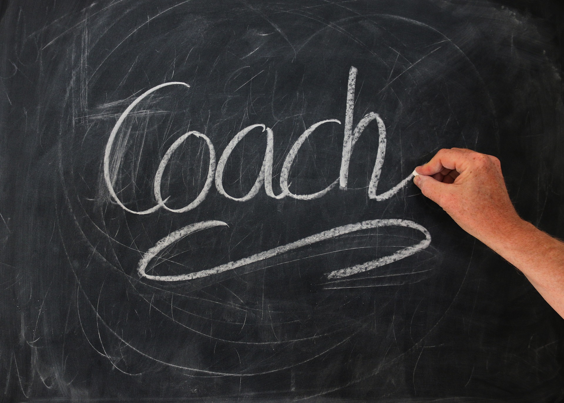 Handwriting the word COACH in a blackboard