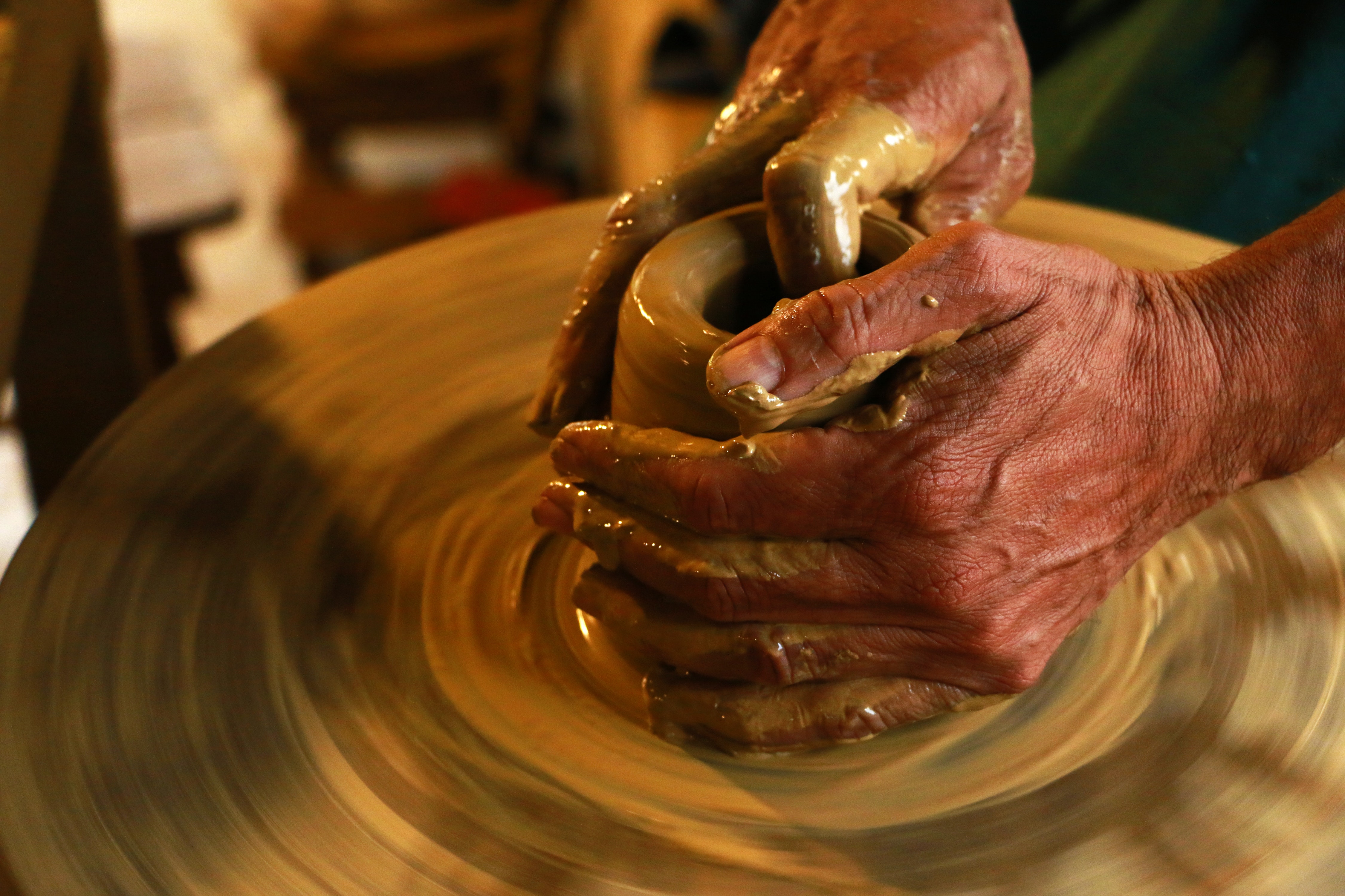 hand working with clay in a ceramist wheel