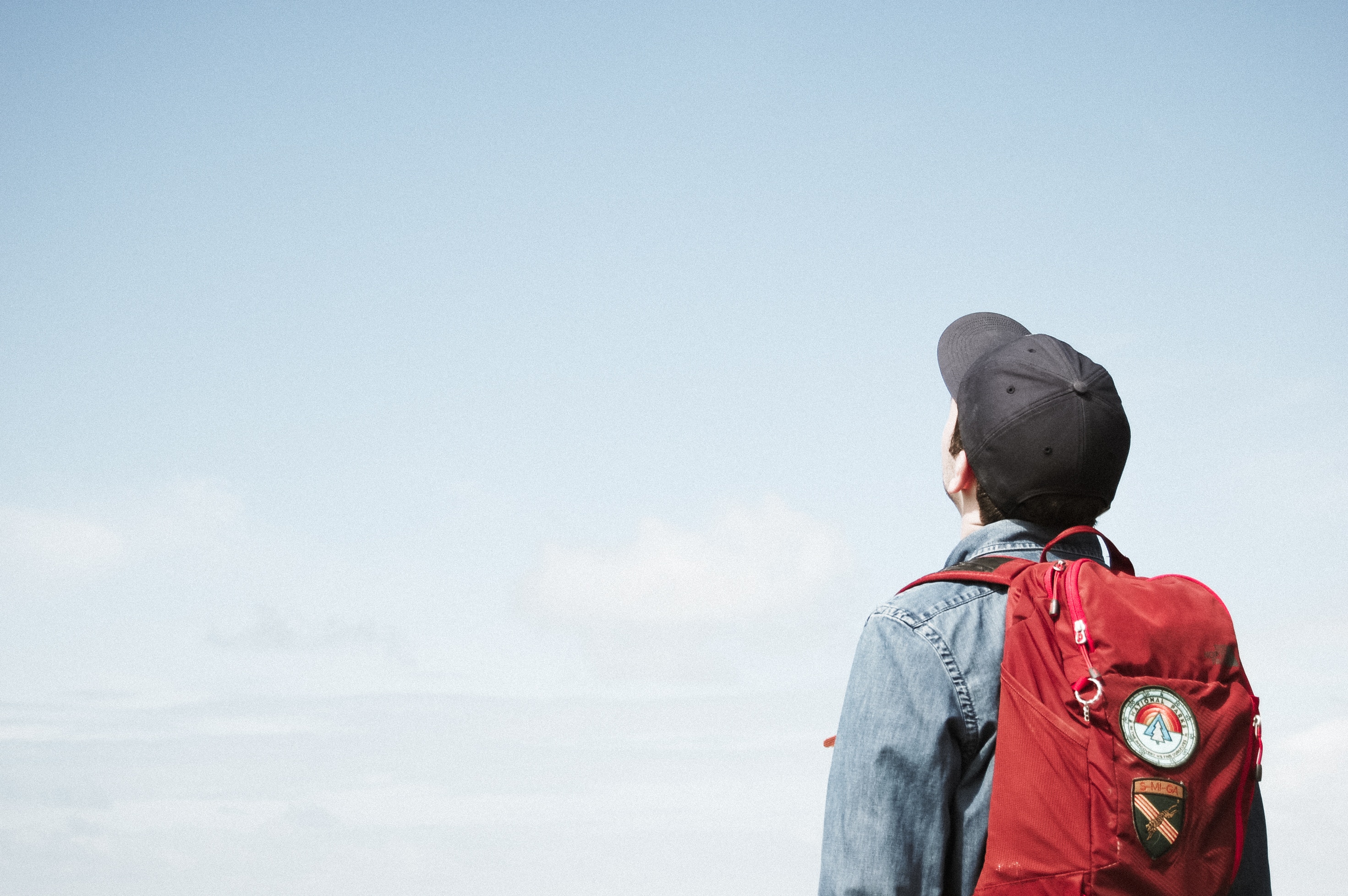 Man with backpack looking at the sky