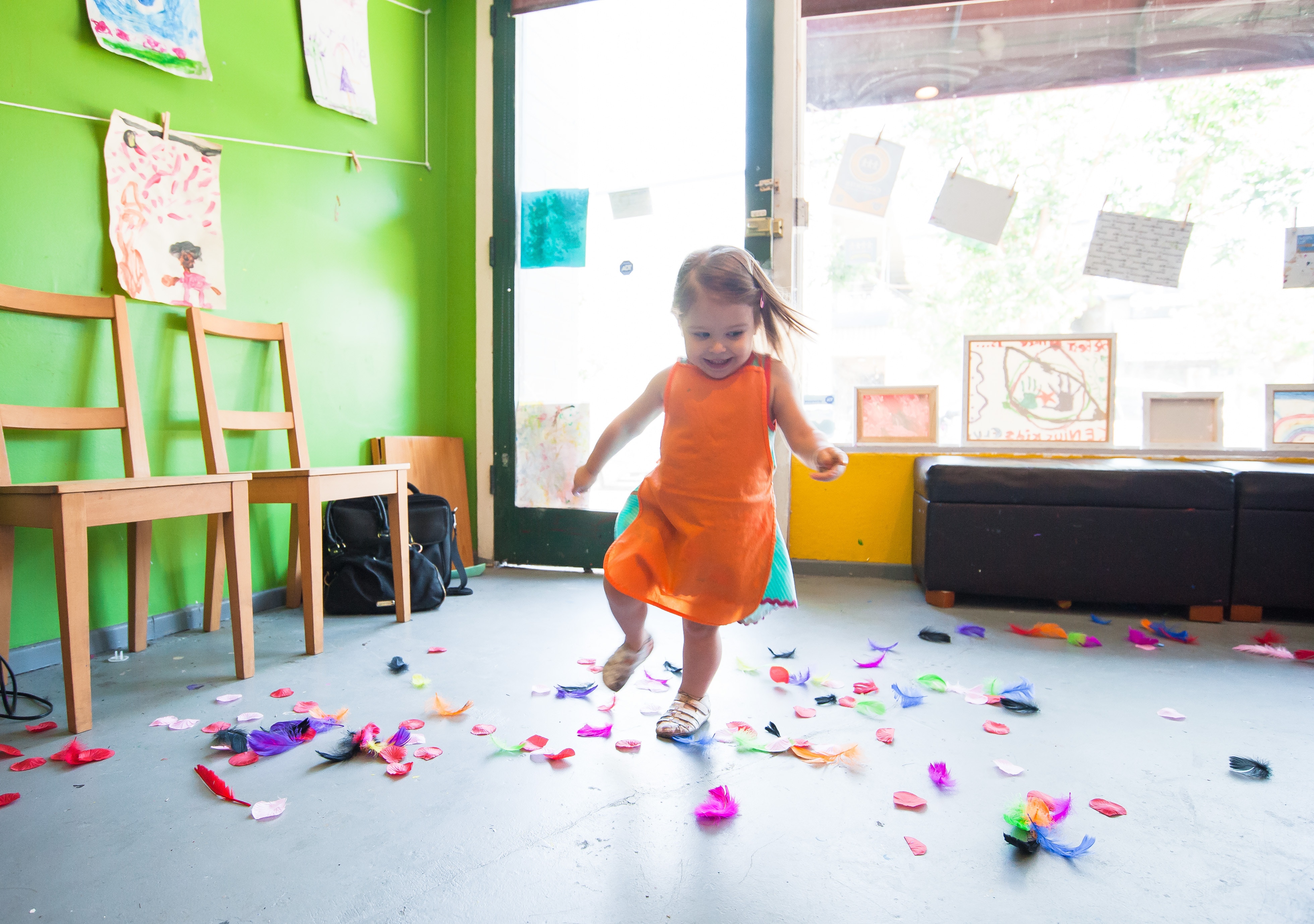Little girl dancing with confetti on the ground